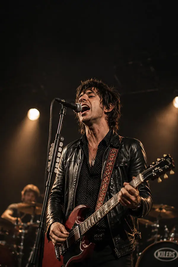 Male rock singer singer on stage while playing the guitar