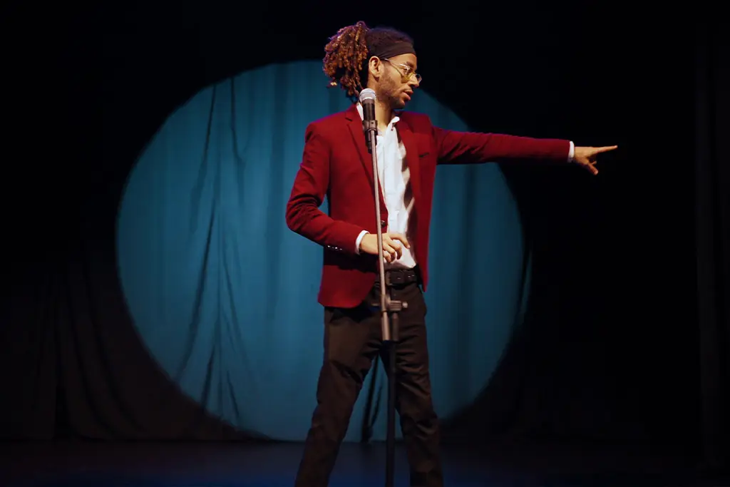 A man on stage pointing a someone