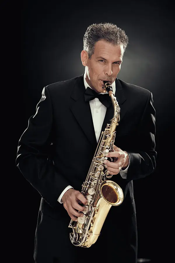 Adult man in suit playing saxophone