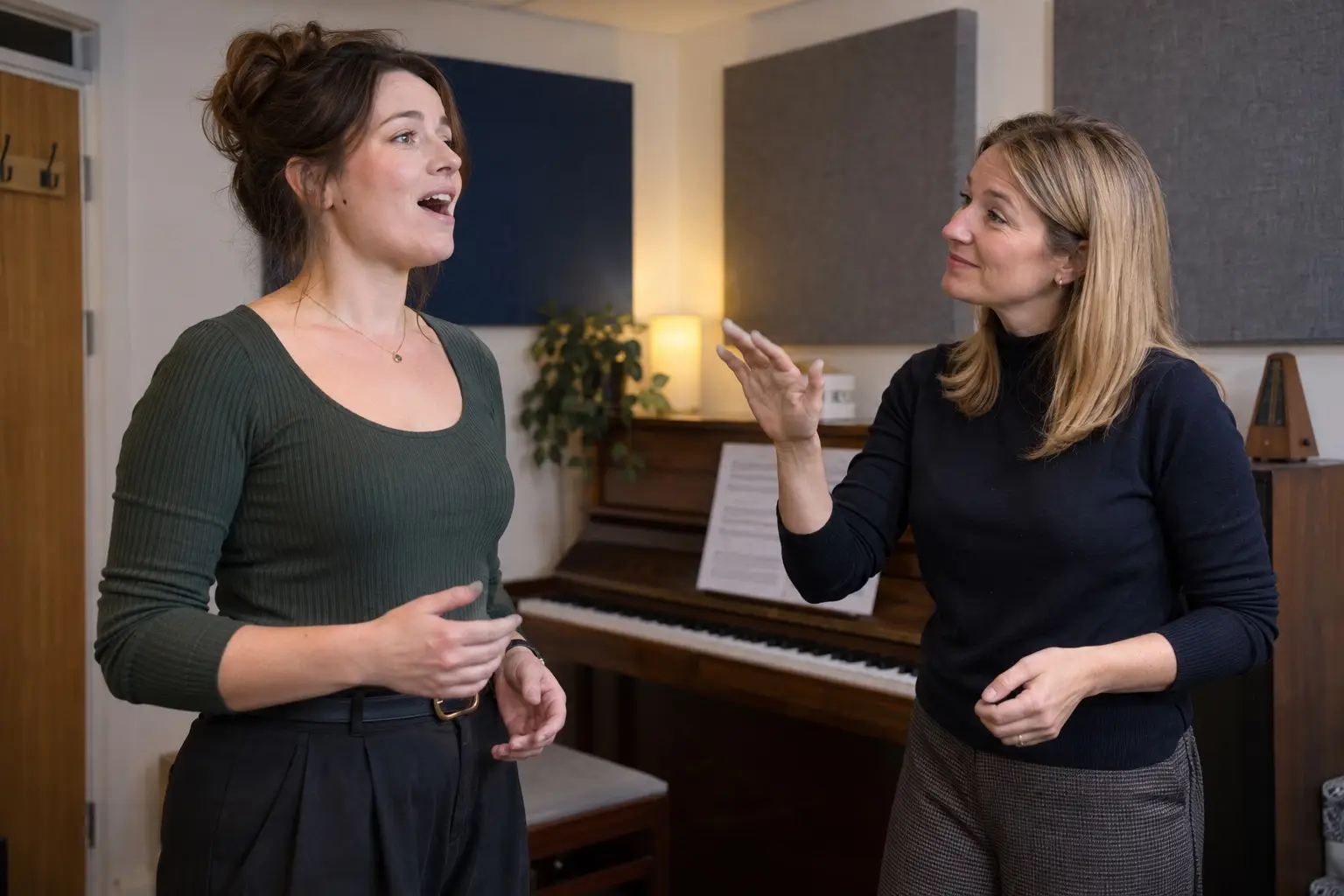 An adult student singing in a one-to-one lesson while her teacher guides her