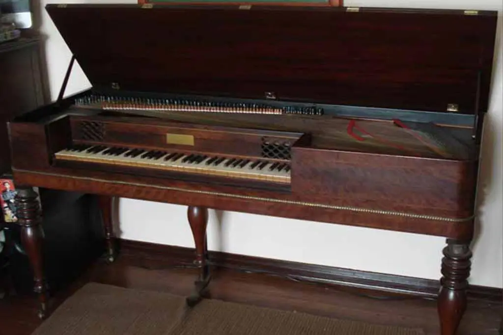 Antique piano with open lid revealing strings