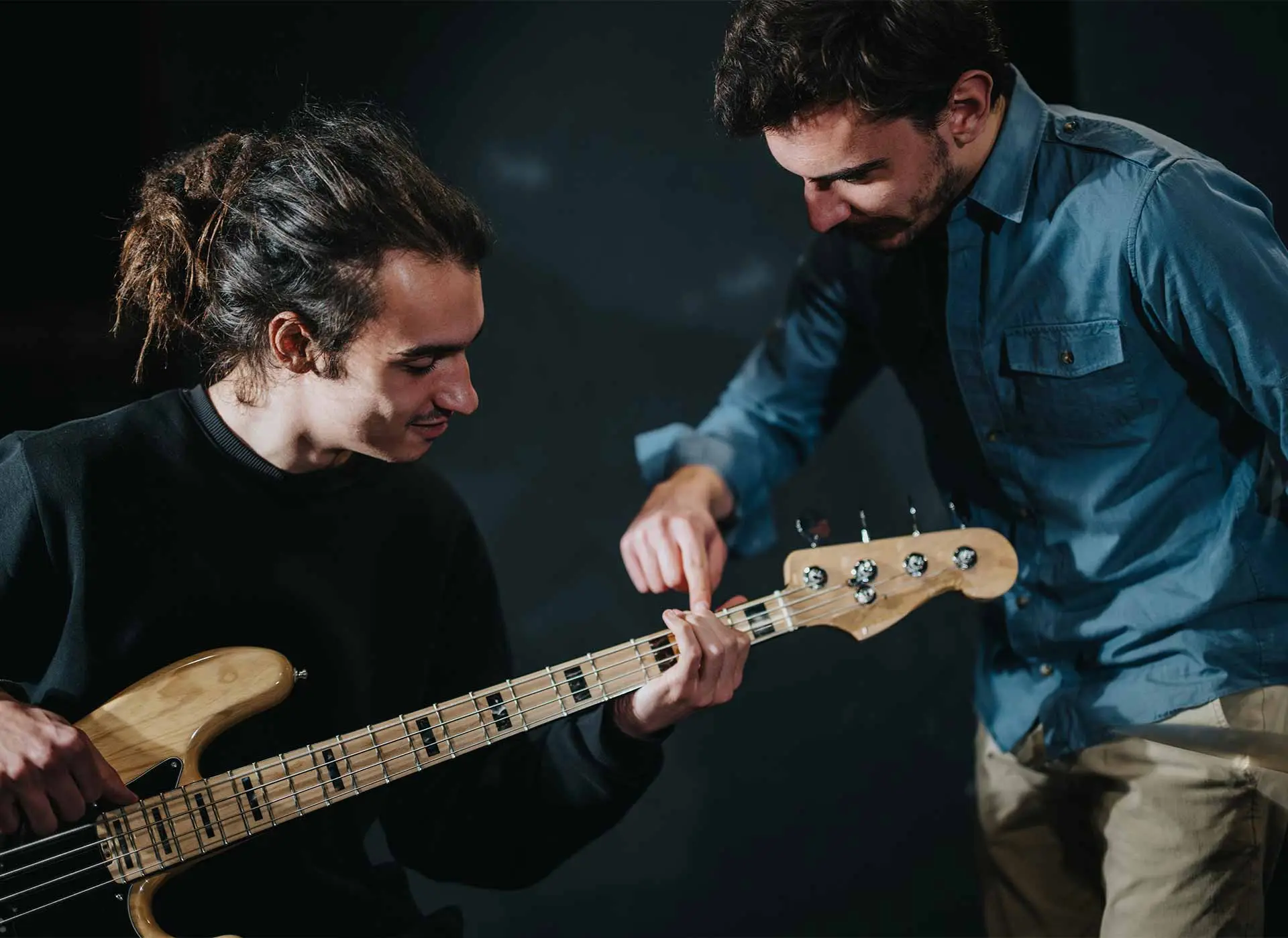 Bass guitar teacher and student having lesson