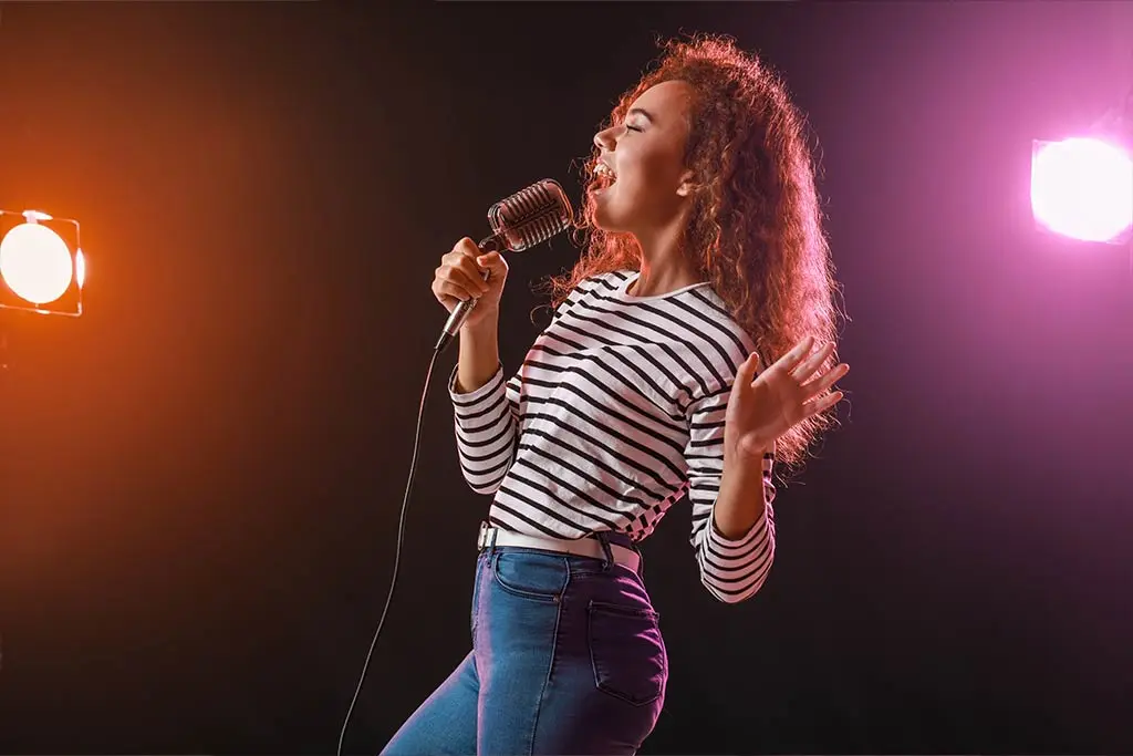 Image of a beautiful woman singing with spotlight background