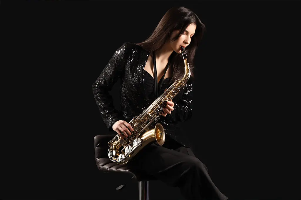 Beautiful woman sitting playing saxophone