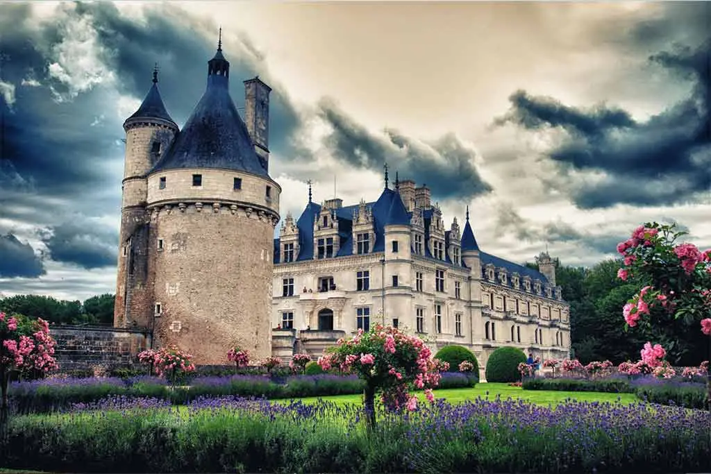 Castle with flower gardens under a cloudy sky