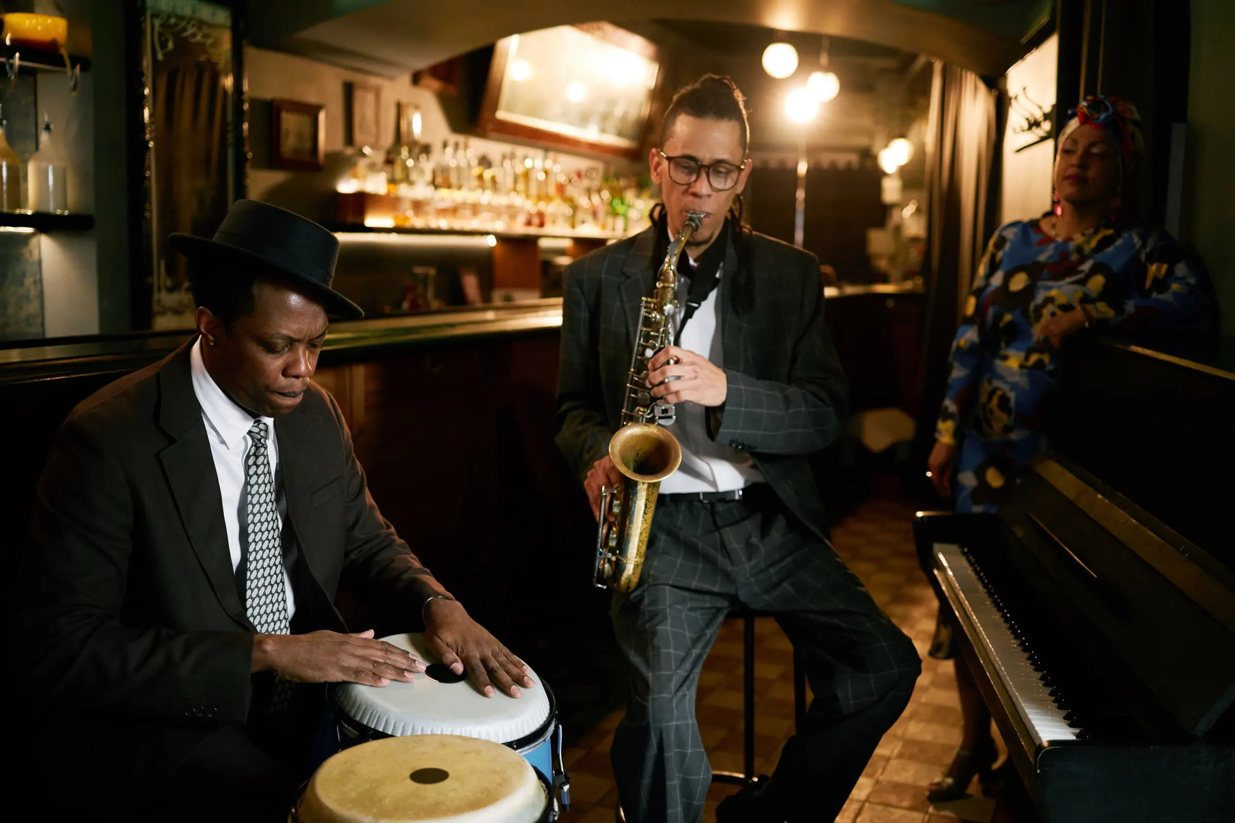 Conga player and saxophonist performing together in a jazz bar.