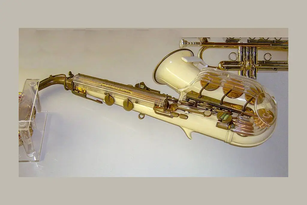 Cream alto saxophone displayed on a clear stand