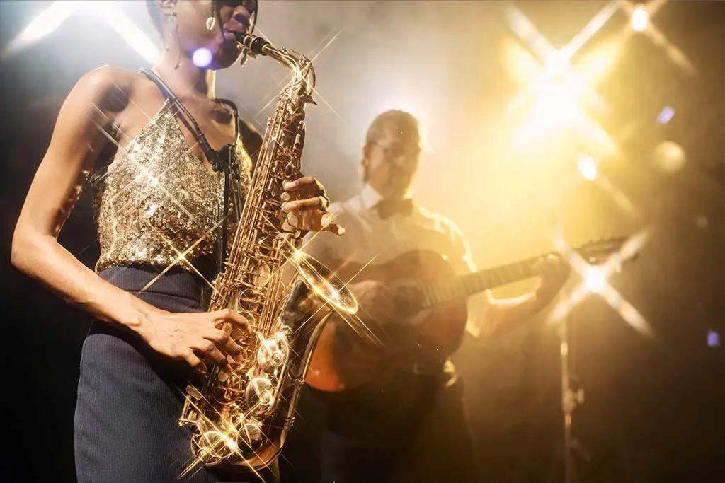 Female saxophonist performing with guitarist in the background