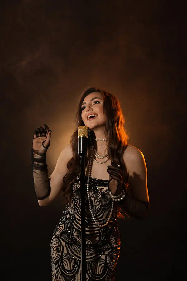 Female singer performing into a vintage-style microphone on stage
