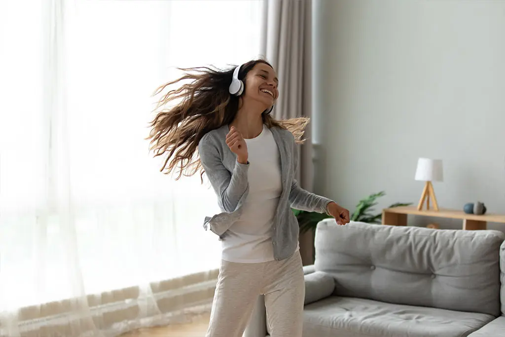 Female teenager listening to music dancing