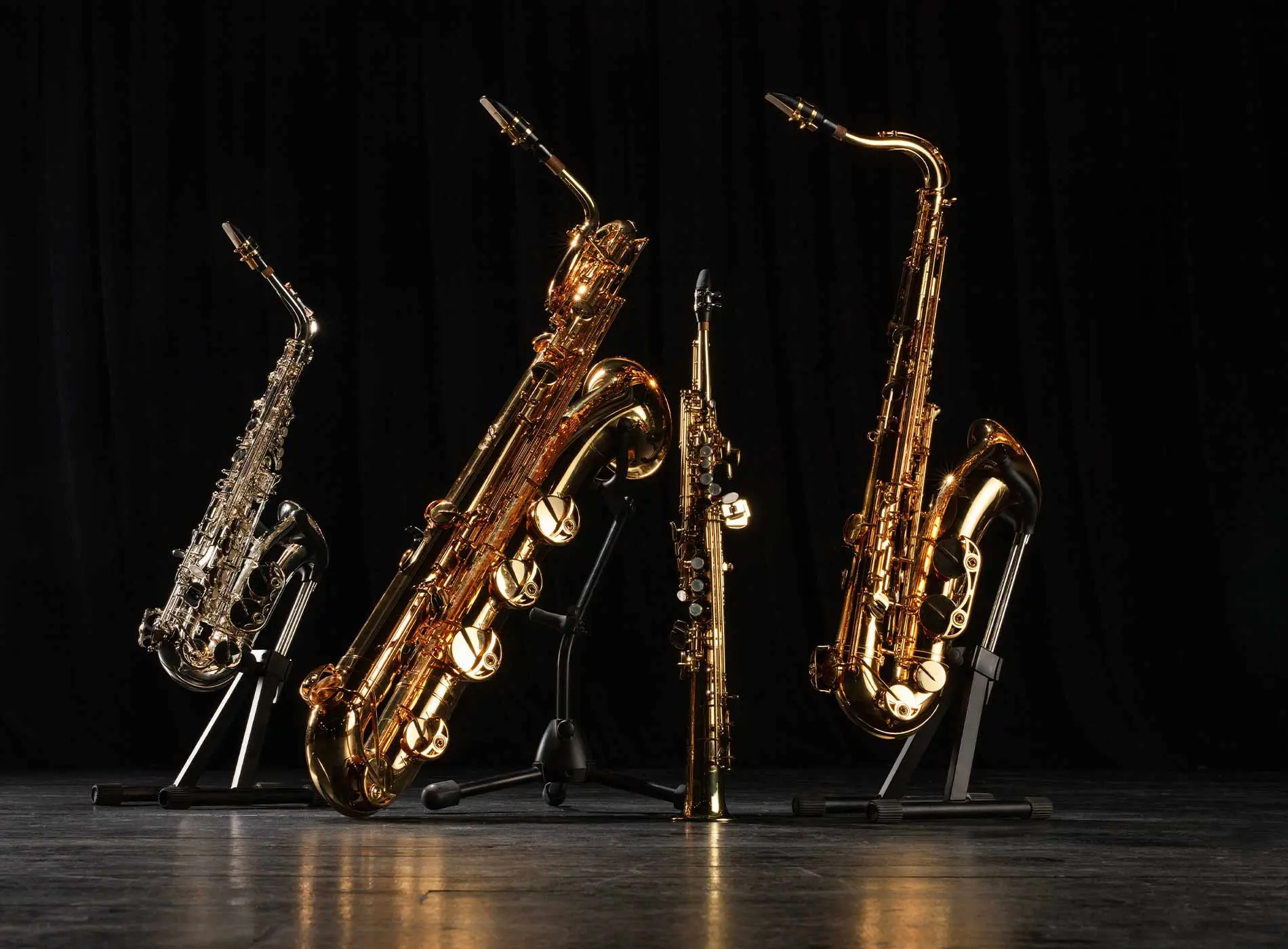 Four different saxophones on stands