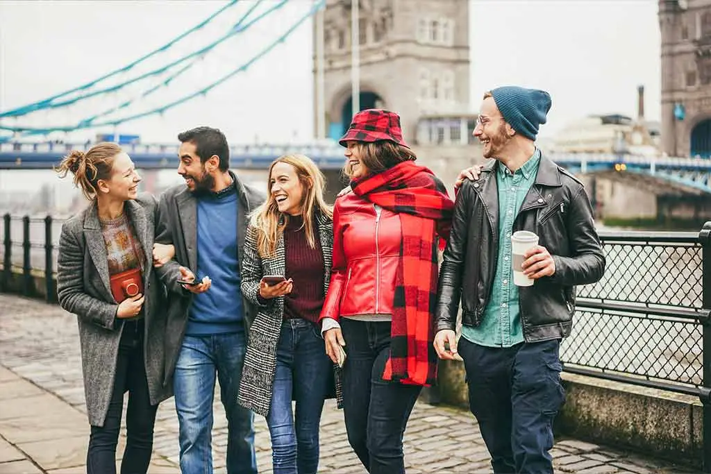 Friends walking by the Thames near Tower Bridge