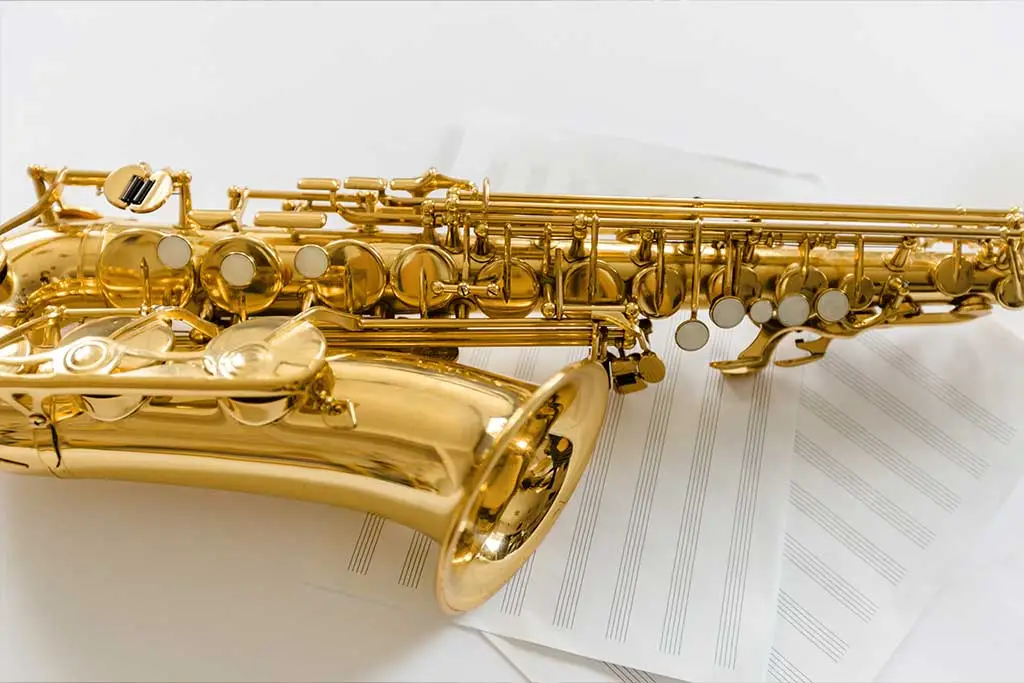 Gold saxophone shown side-on over sheet music