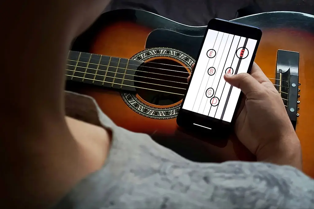 Hand holding a phone with a guitar