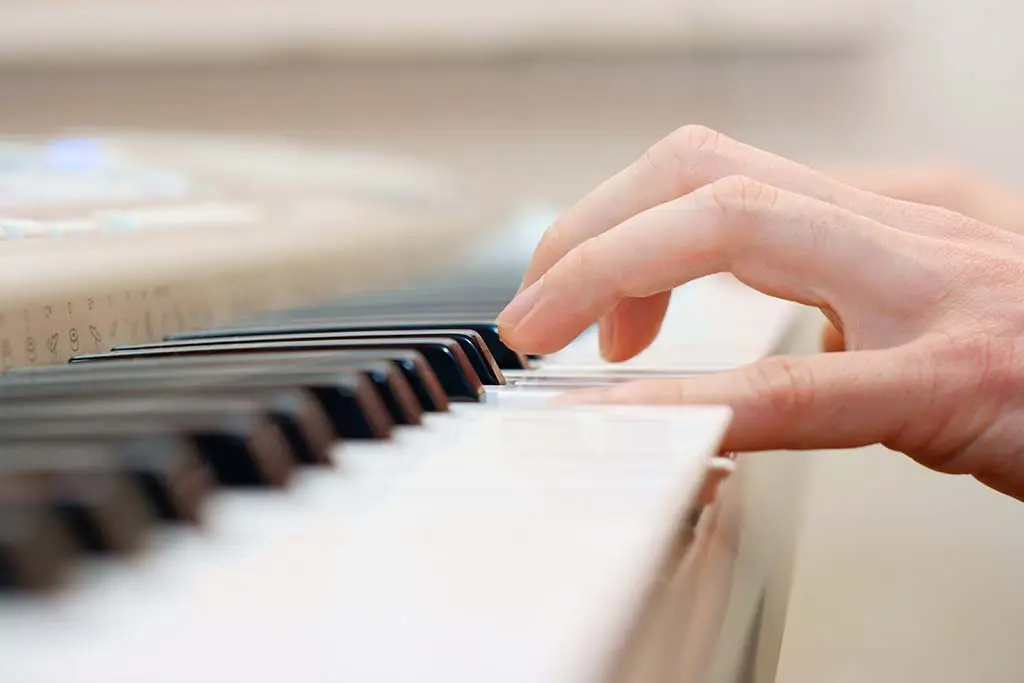 Hand playing piano keys in close-up