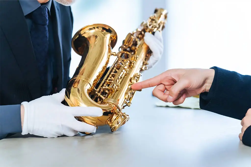 Hand pointing at the saxophone