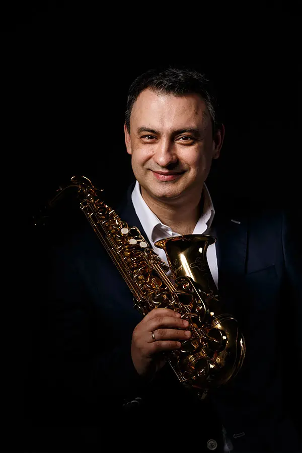 Happy man holding a saxophone