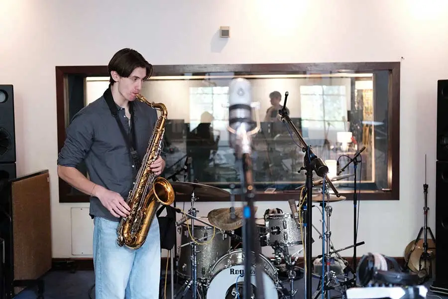 Harris, LMT saxophone teacher, playing tenor saxophone in a recording studio