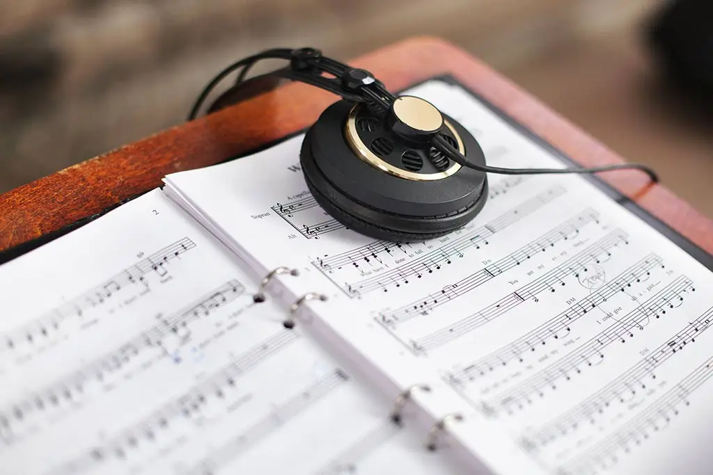 Headphones resting on an open sheet music binder