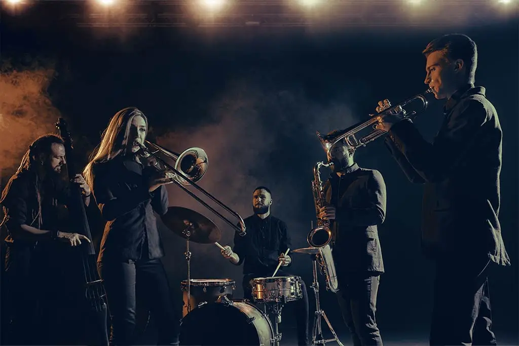 Jazz band performing on stage with trumpet, trombone, saxophone and drums