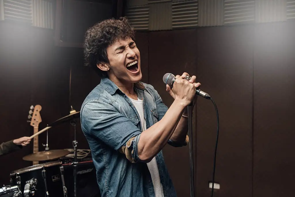 Image of a male lead vocalist singing in studio