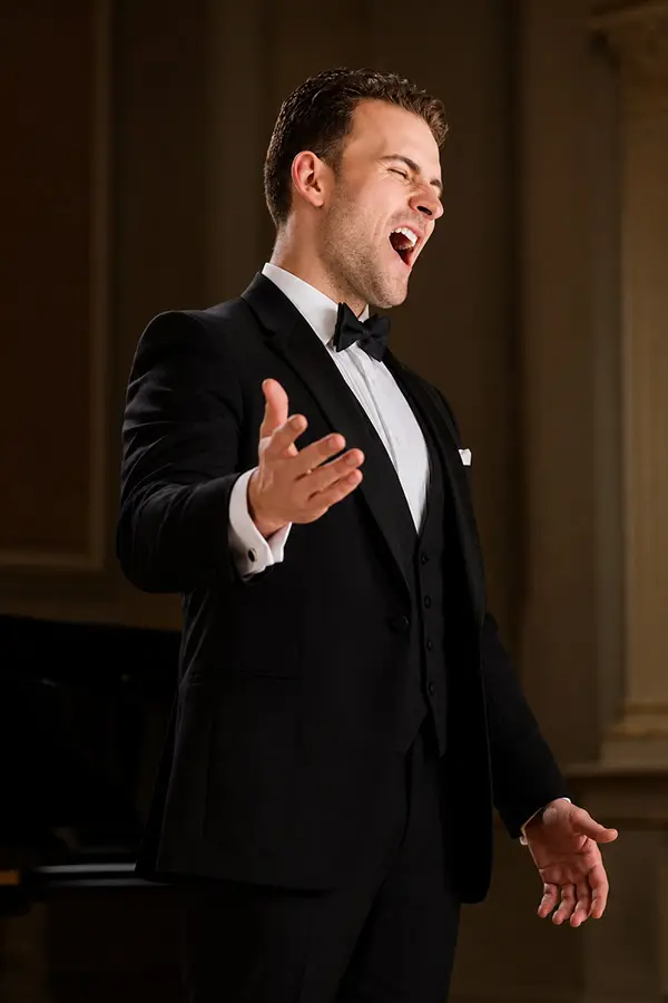 Male singer performing in a black tuxedo