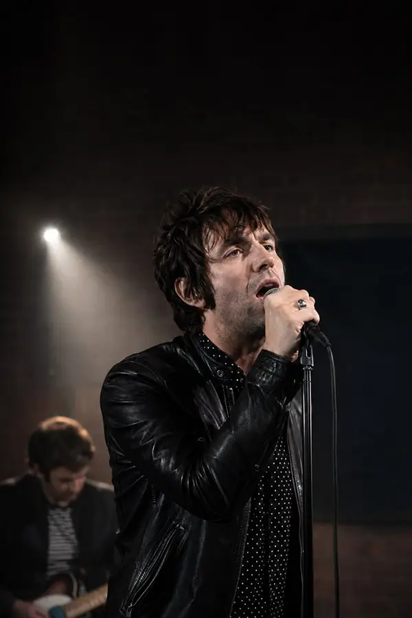 Male singer in a leather jacket performing on stage