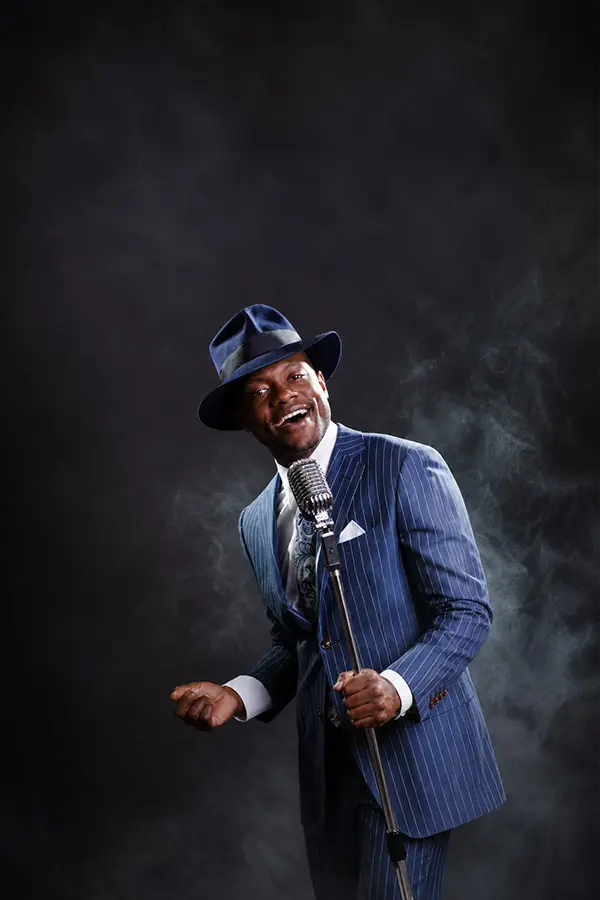 Male singer in a suit performing with a vintage microphone