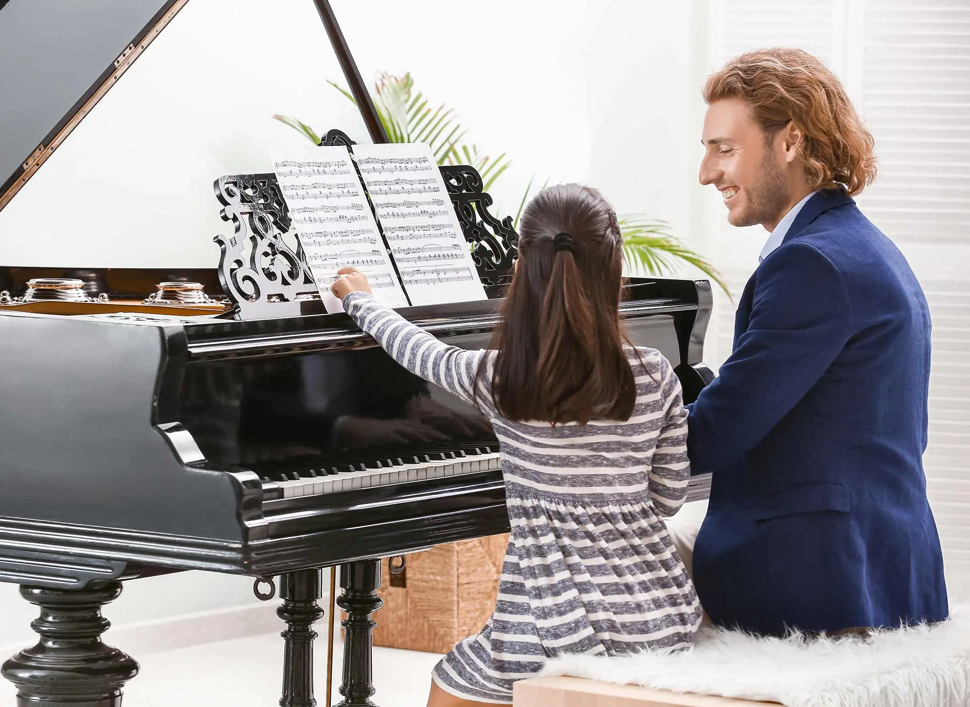 Piano teacher teaching a child how to play piano