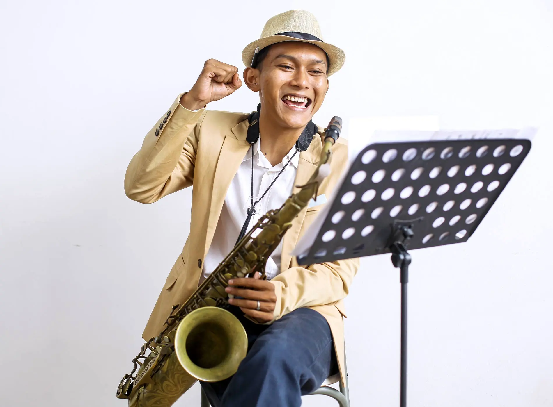 Saxophonist with hat cheering up with saxophone