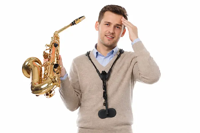 Man with saxophone touching his head