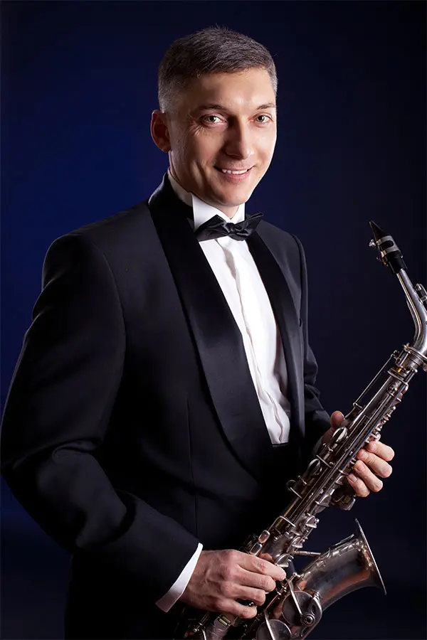 Man in a tuxedo holding a soprano saxophone