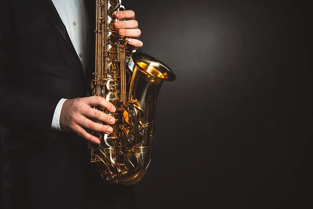 Man in suit holding a saxophone