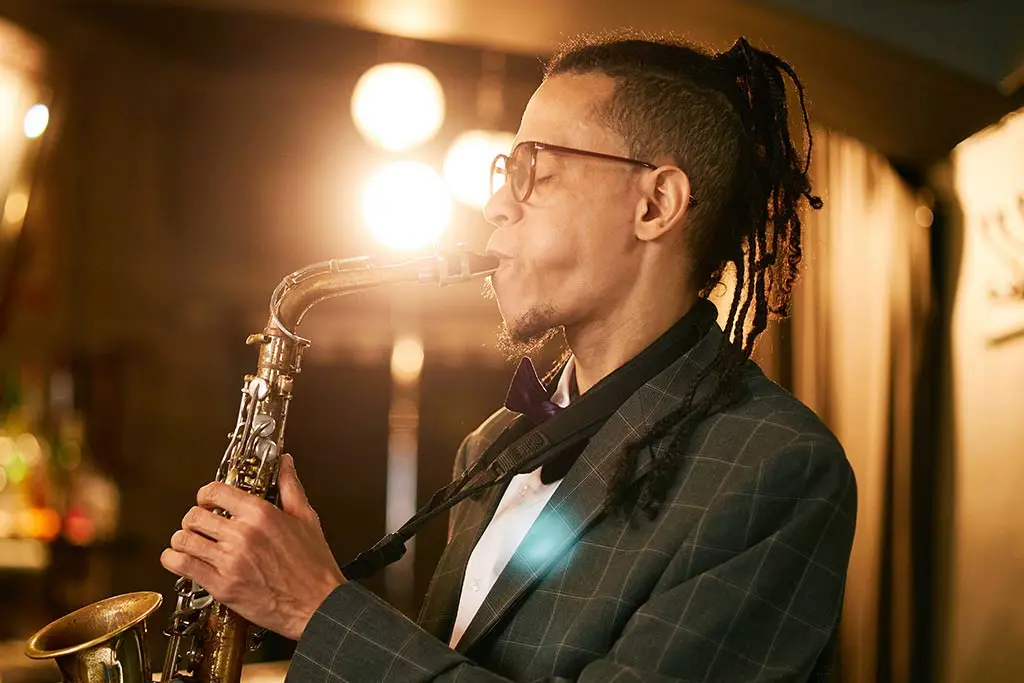 Man in a suit playing saxophone in side profile
