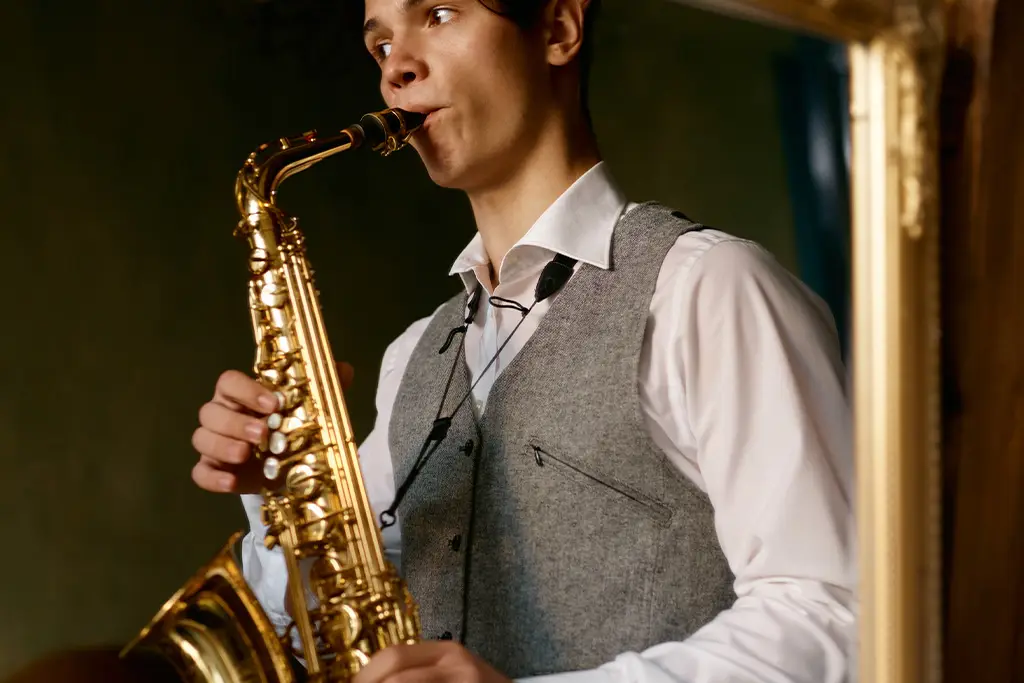 Man playing an alto saxophone reflected in a mirror