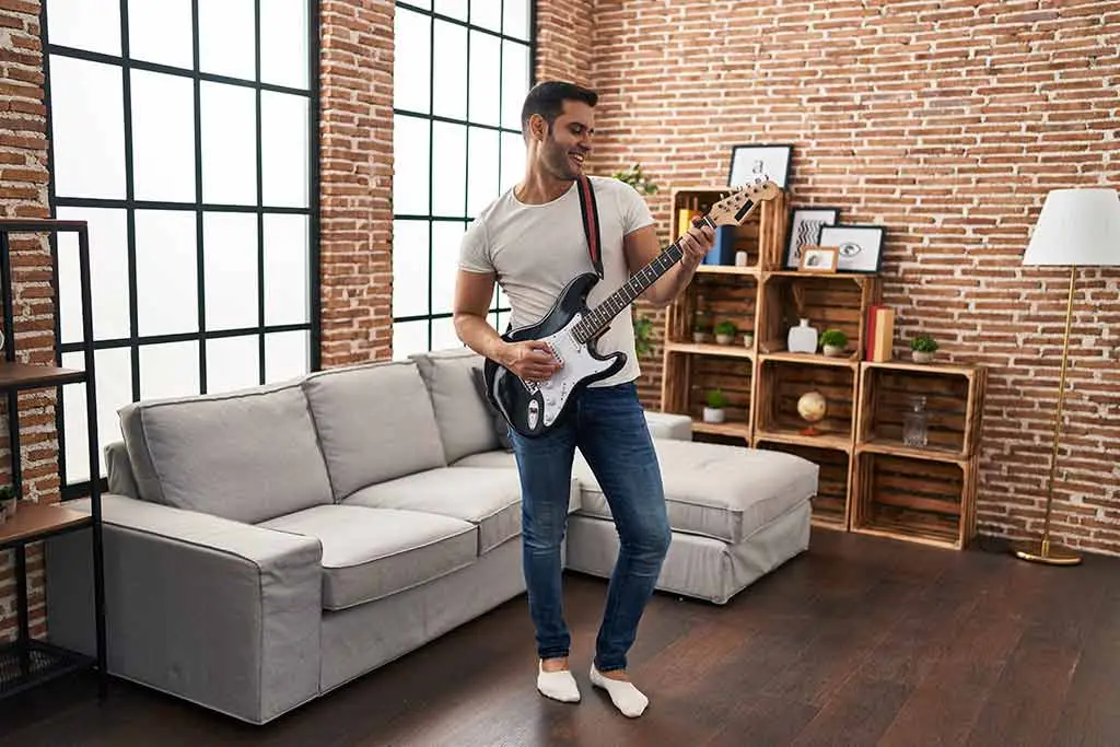 Man playing guitar at home