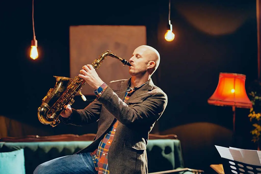 Man playing saxophone at home