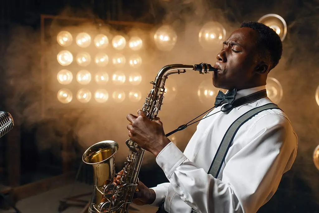 Side view of a man in a bow tie playing saxophone