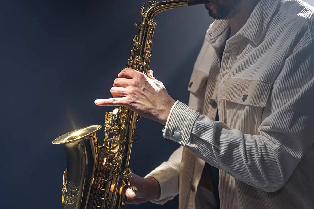 Close-up of a man in a striped shirt playing saxophone
