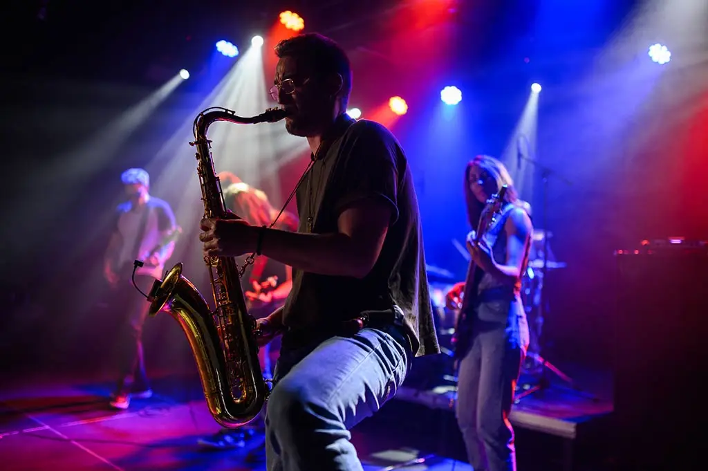 Man playing tenor saxophone with a band on stage