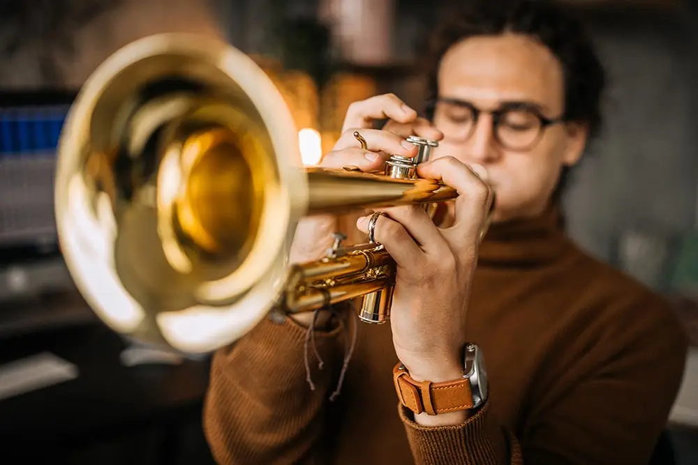 Close-up of a man playing the trumpet, focused on the bell of the instrument
