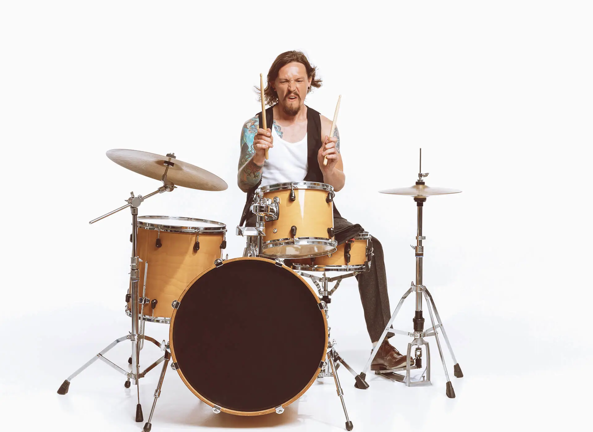 Man playing a yellow drum kit in a studio