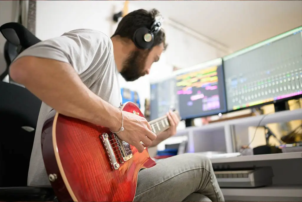 Man practising guitar in the studio