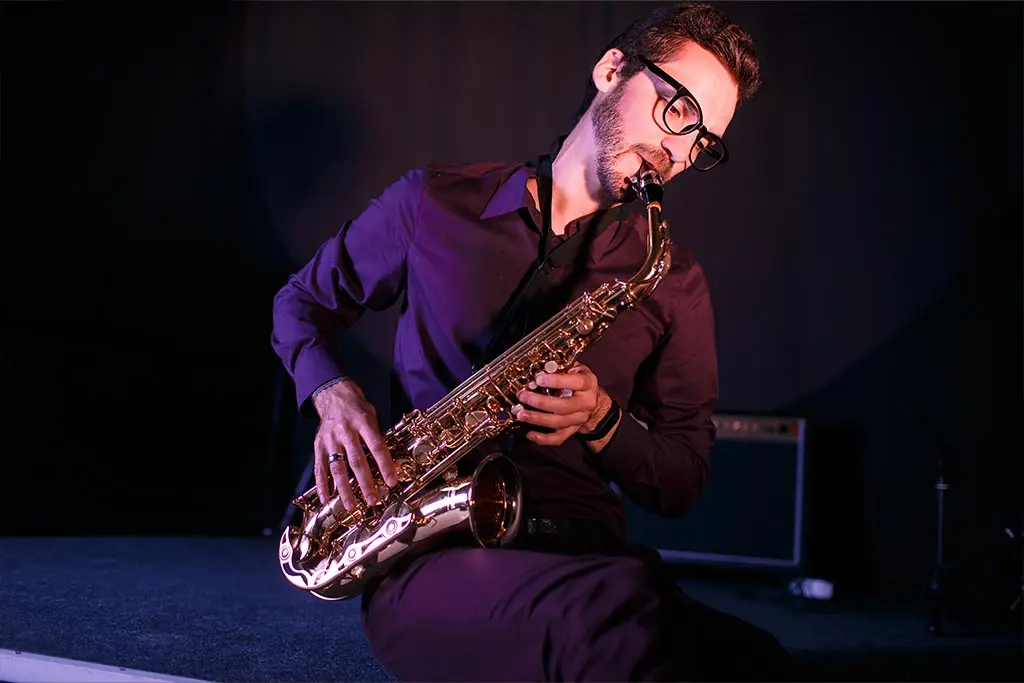 Man sitting playing saxophone