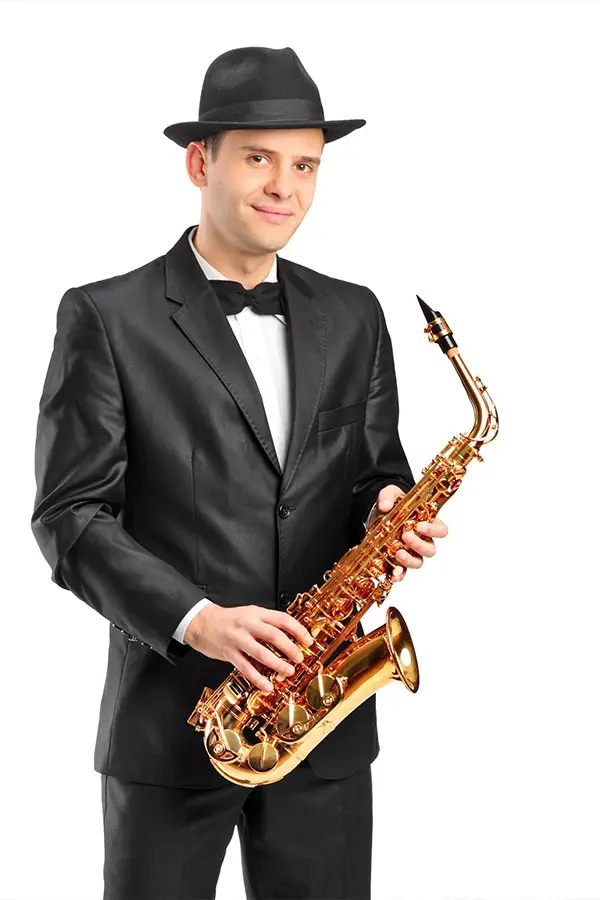 Man wearing a suit smiling holding a saxophone
