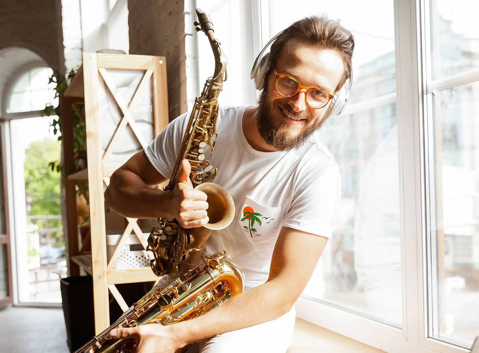 Man with glasses and headphone smiling and making thumbs up