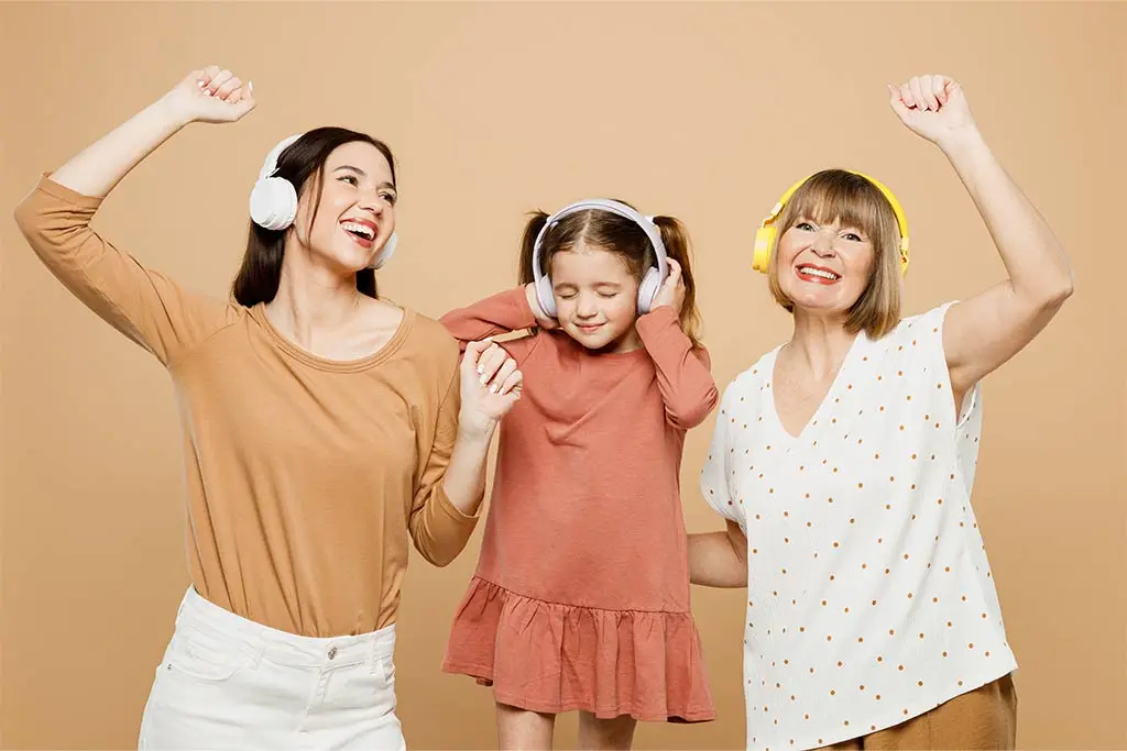 Mother and daughter and grandmother dancing to music