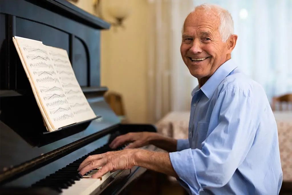 Old man playing the piano at home