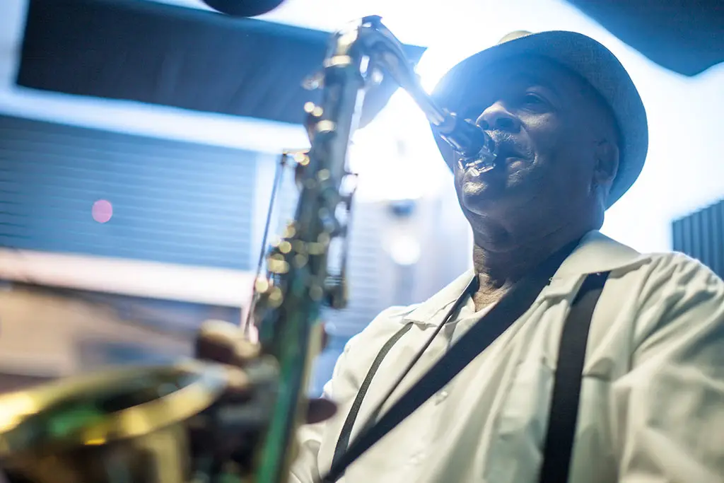 Older man in a hat playing saxophone