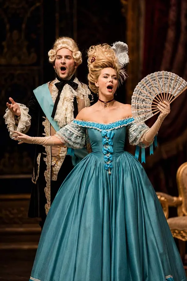 Opera singers performing on stage in period costumes